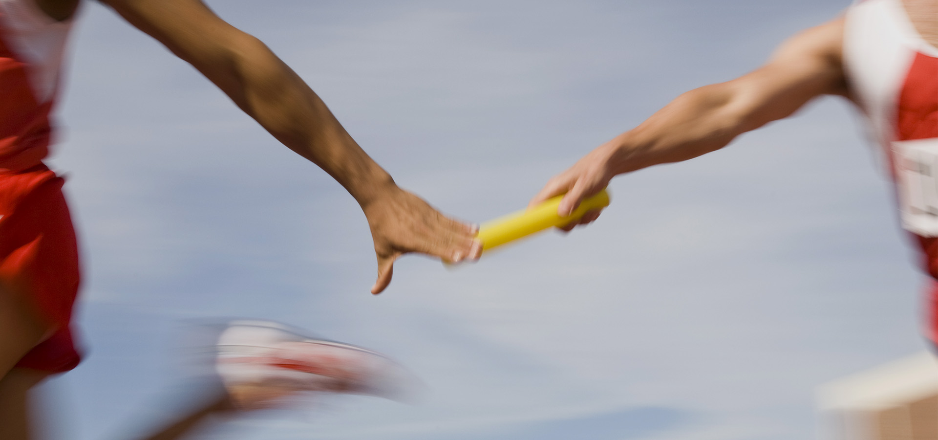 Athletes passing relay baton